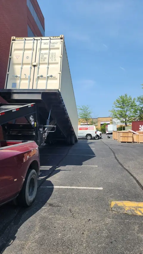 40ft high cube shipping container secured on tilt-bed truck for delivery in Baltimore