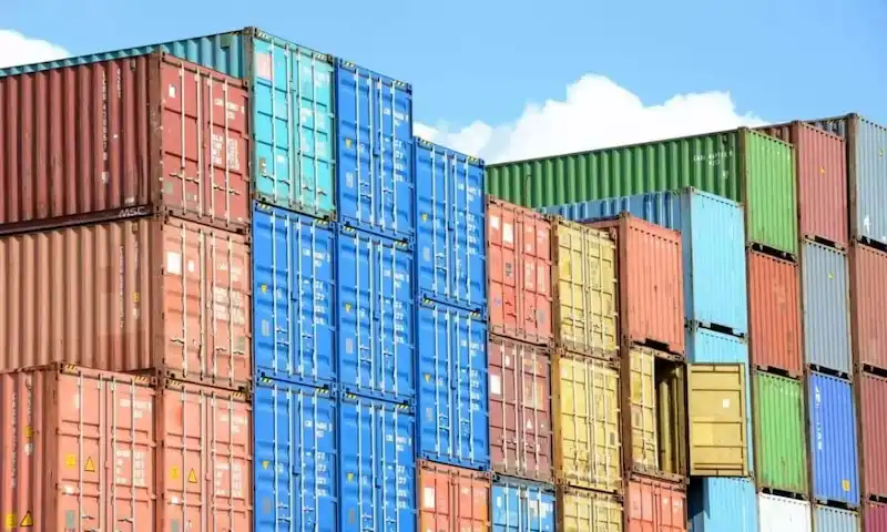 Colorful stacks of red, blue, green, and yellow shipping containers under a bright sky, symbolizing massive inventory volume.