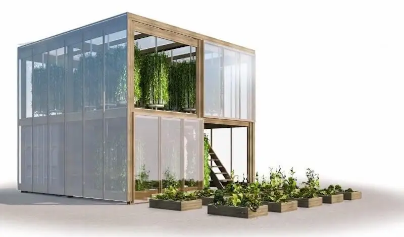 Two-story modular greenhouse built from glass and wood, with lush vertical farming vines growing inside.