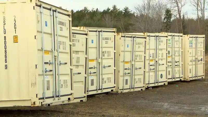 Row of clean, beige 20ft shipping containers with door specs visible, symbolizing new, high-quality inventory.